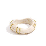 Resin bangle bracelet with studs in a striped pattern