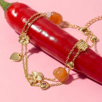 Charm bracelet with orange beads, flowers and hearts