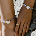 Rope bracelet with shell and floral design beads