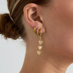 Earrings with dangling hearts at different heights