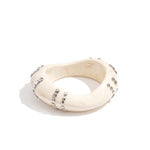 Resin bangle bracelet with studs in a striped pattern
