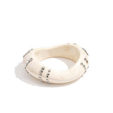 Resin bangle bracelet with studs in a striped pattern