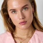 Necklace with decorated cross pendant and charms