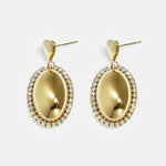Statement earrings with an oval charm surrounded by stones