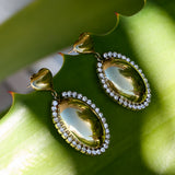 Statement earrings with an oval charm surrounded by stones
